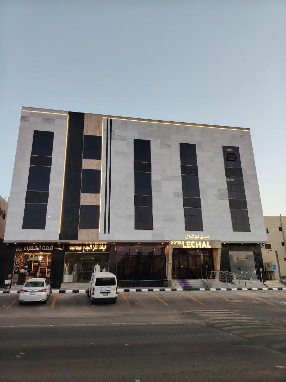 a building with cars parked in front of it at فندق لوشال LECHAL Hotel in Medina
