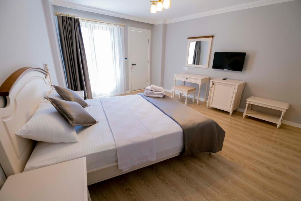 a bedroom with a large bed and a television at Icarus Alaçatı in Çeşme
