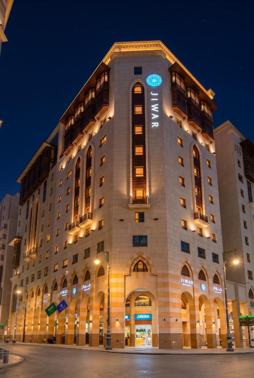 a large building with lights on it at night at Jiwar Al Madina Hotel in Medina