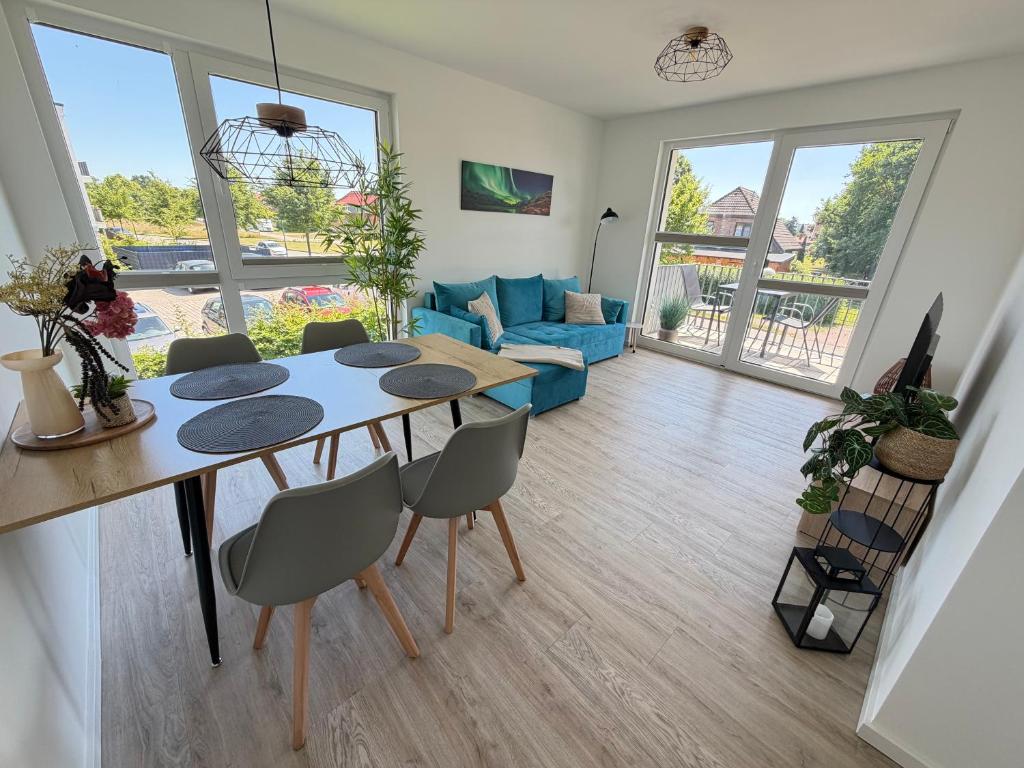 a dining room and living room with a table and chairs at RegioStyle Gemütliche Wohnung im Schaalseepark! in Zarrentin