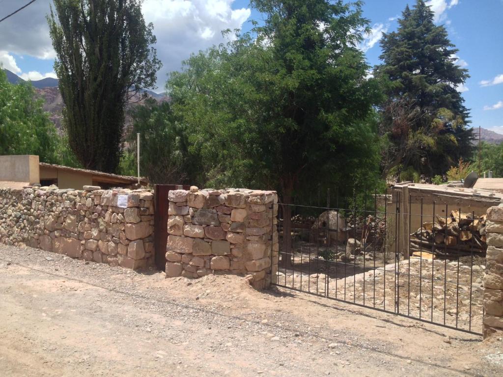 una valla frente a una pared de piedra en La Pirquita en Tilcara