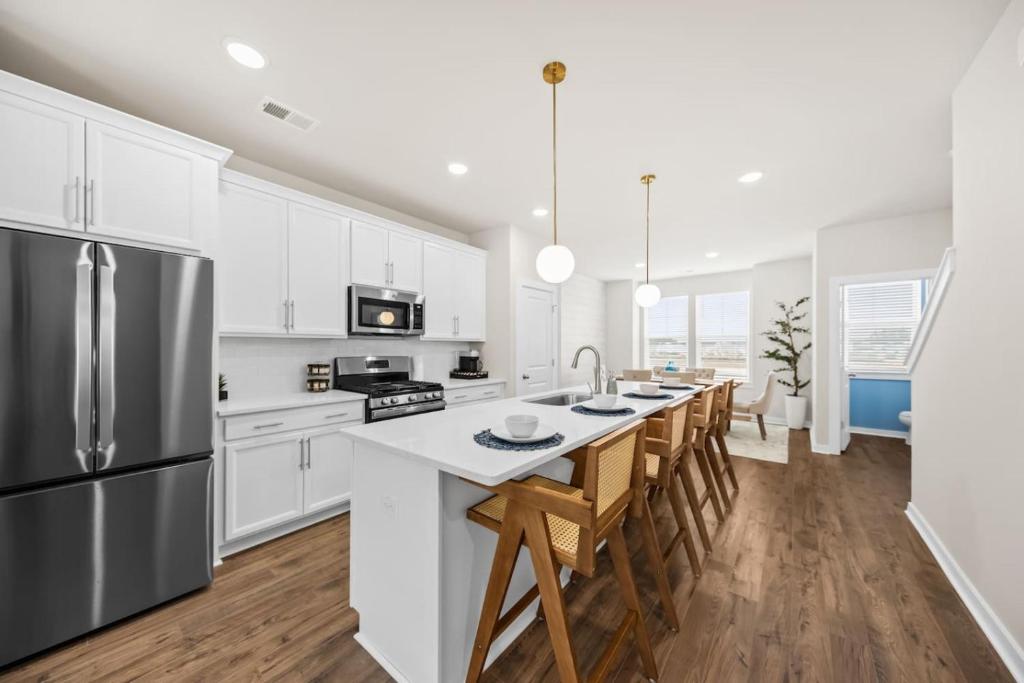 a kitchen with white cabinets and a stainless steel refrigerator at Sweetgrass Row at Cane Bay in Summerville