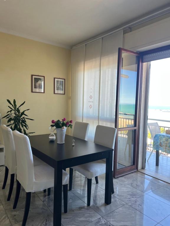a dining room with a black table and white chairs at Casa Ada in Termoli