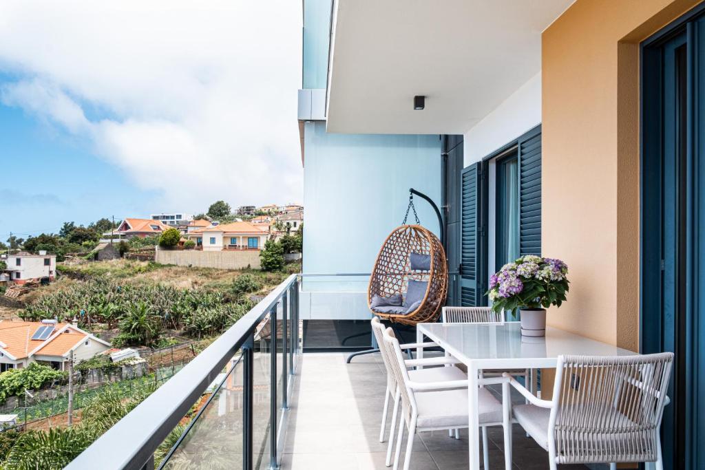 a balcony with a white table and chairs at Canhas Ocean View in Ponta do Sol