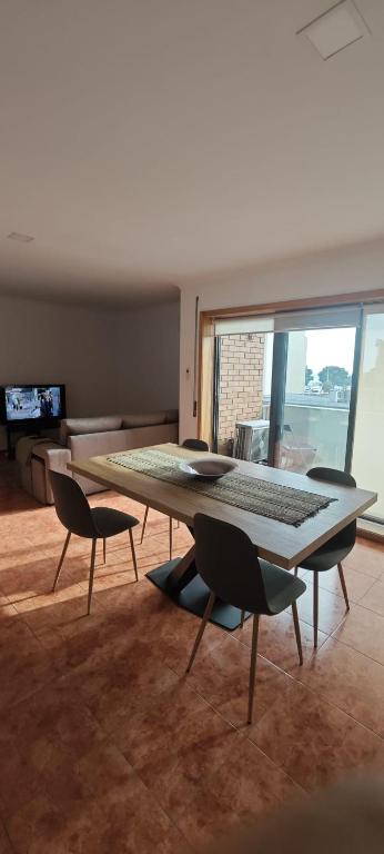 a table and chairs in a room with a large window at 2 Bedrooms Apulia Front Beach Flat in Apúlia