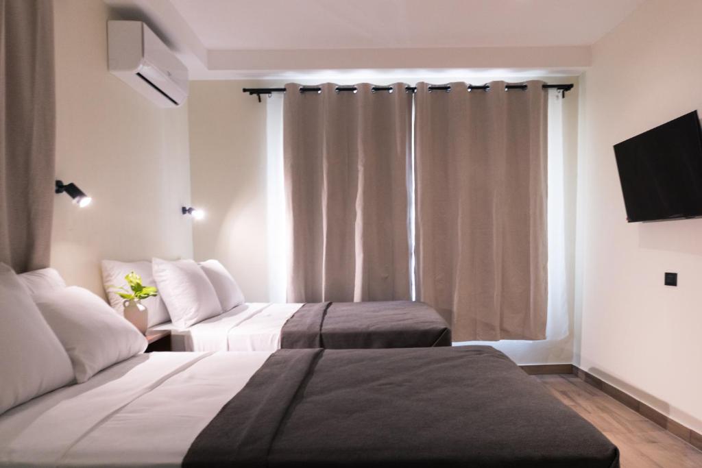 a hotel room with two beds and a television at Hotel Casa Arbórea in San José