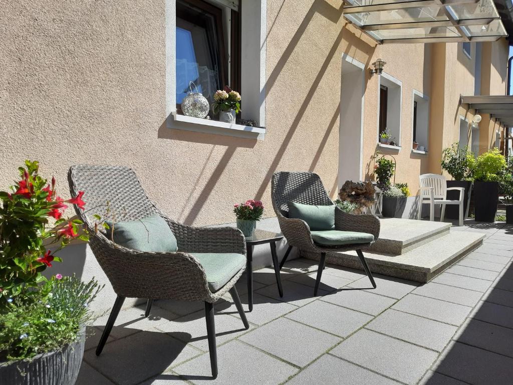 a patio with three chairs and a table and a window at Ferienwohnung Purwins in Ebermannstadt