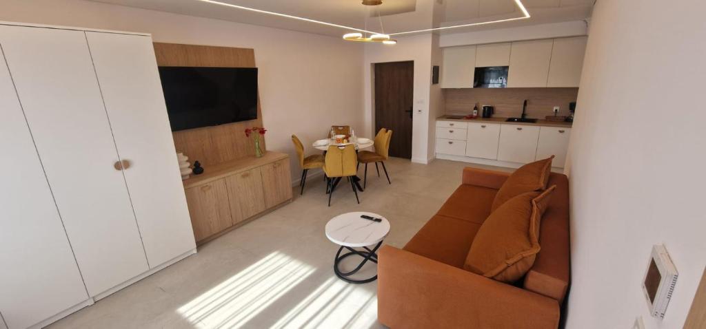 a living room and kitchen with a couch and a table at Sea Apartments in Łeba