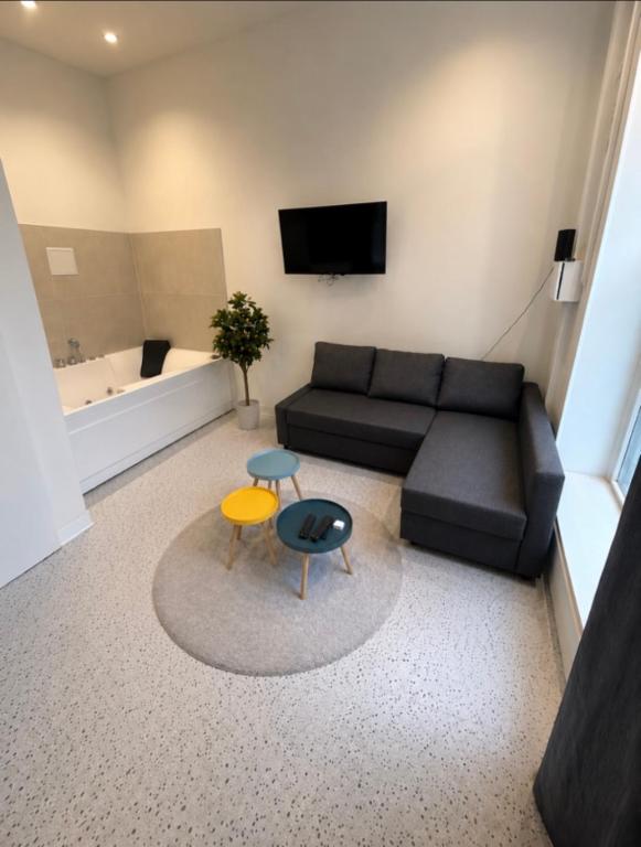 a living room with a couch and a table at Appartement Central avec Jacuzzi Privé I Strasbnb in Strasbourg