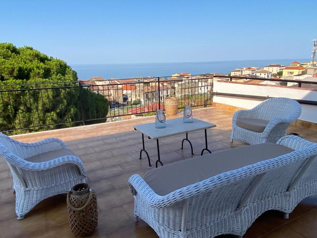 a patio with wicker chairs and a table and the ocean at Terrazzo Vista Mare Mozzafiato in Cariati