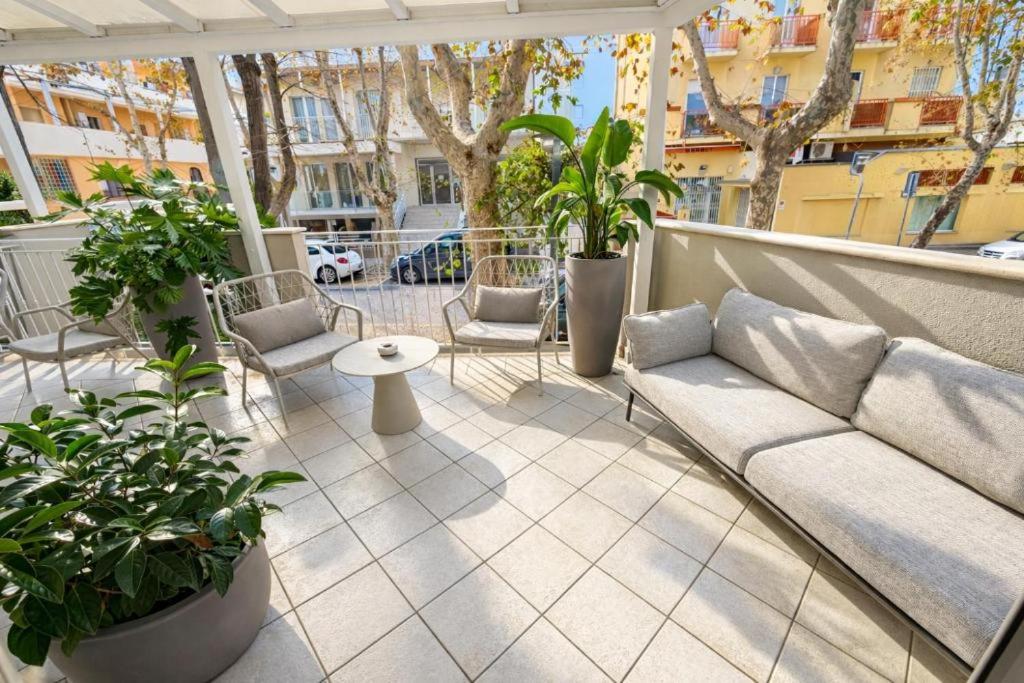 a patio with a couch and chairs on a balcony at Dipendenza Hotel Regal in Rimini