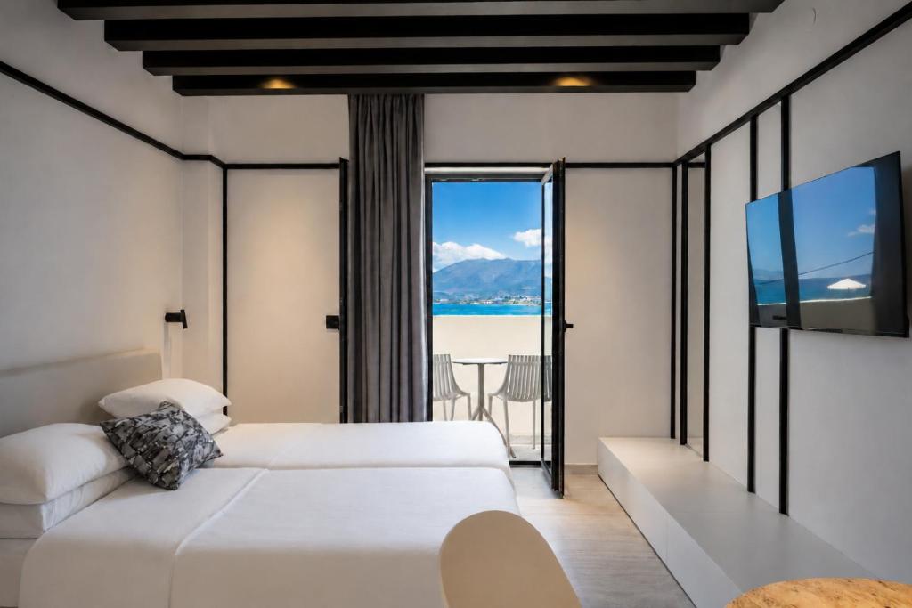 a bedroom with a bed and a view of the ocean at Veneto Sea View Apartments in Stalís
