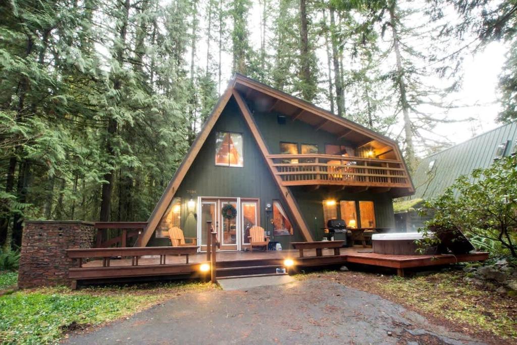 a small house in the woods with a large deck at Forest View Chalet in Glacier