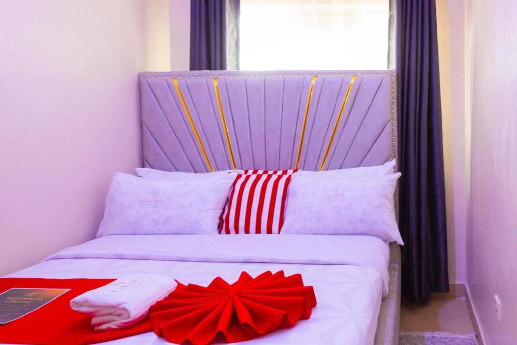 a bed with a red bow on top of it at Cherve BnB in Nakuru