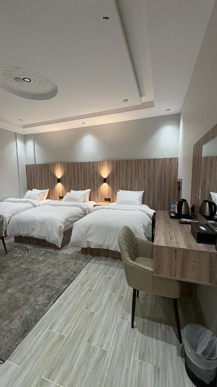 a large bedroom with two beds and a desk at Qubaa Soul Studio 2-3 in Medina