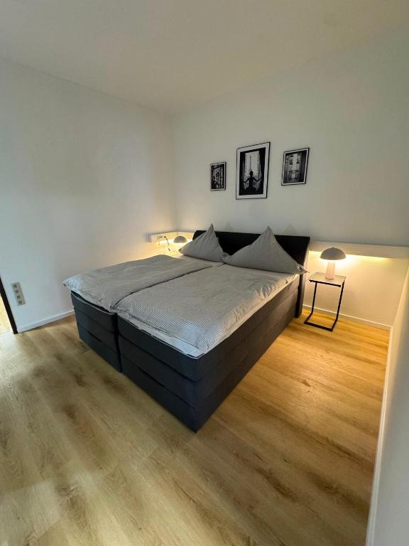 a bedroom with a large bed and a wooden floor at City Apartment in Siegen