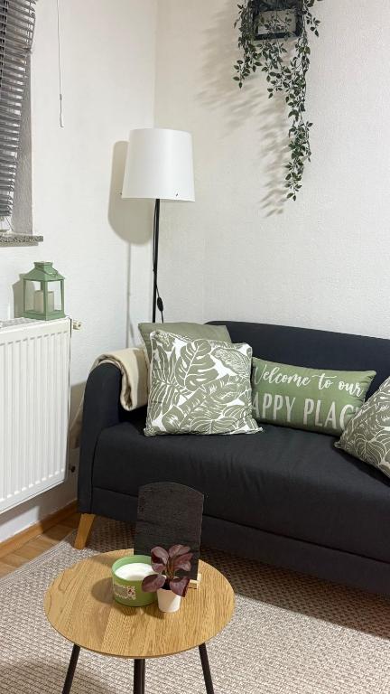 a living room with a black couch and a coffee table at The Nook Apartment in Jesenice