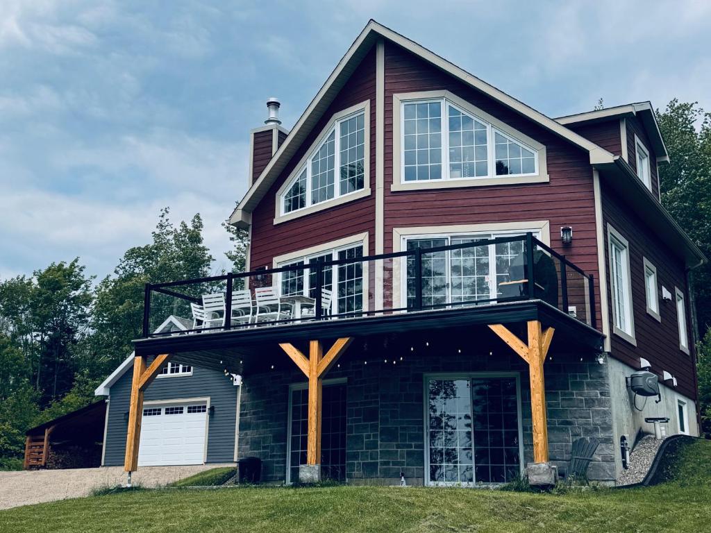 a large house with a balcony on top of it at Night Sky Cottage in Saint-Joachim
