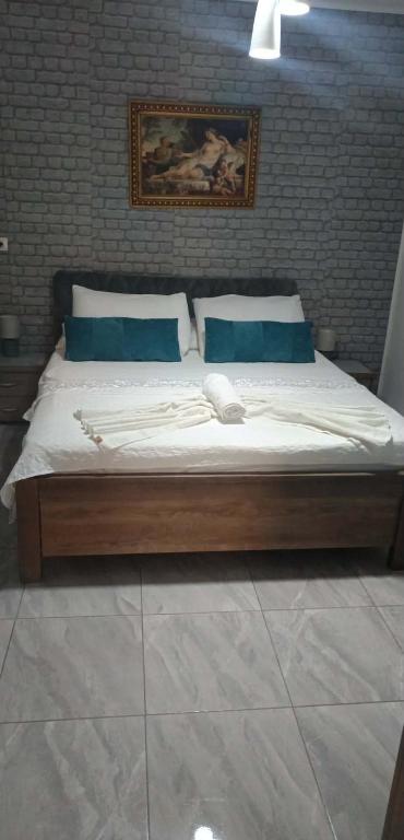 a large bed with blue pillows in a bedroom at Fatos in Pogradec