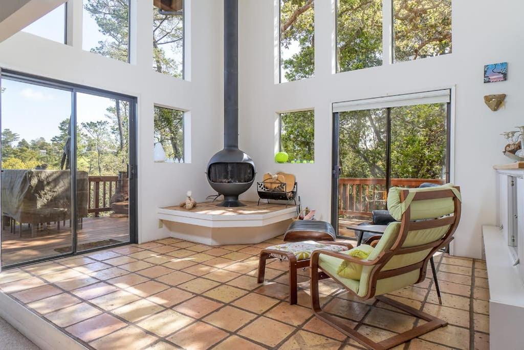 a living room with a fireplace and large windows at The Silver Lady in Cambria
