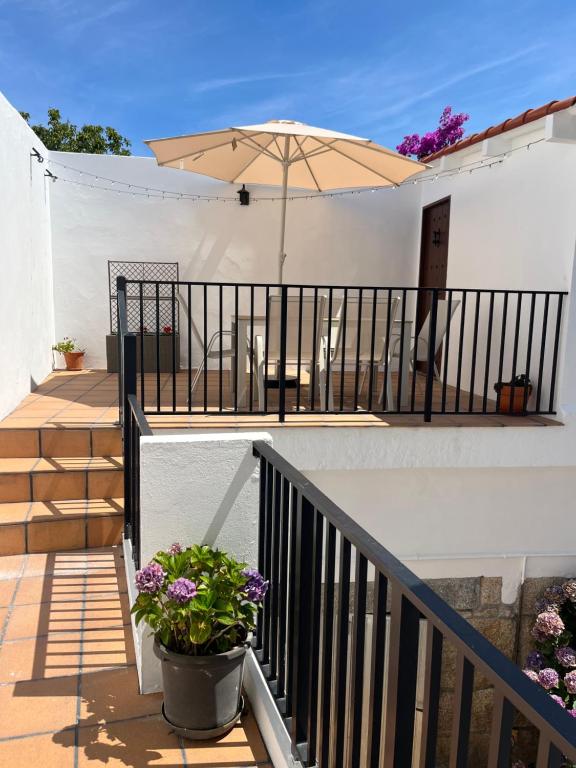 a balcony with an umbrella on a white building at Apartamento O Vento in O Grove