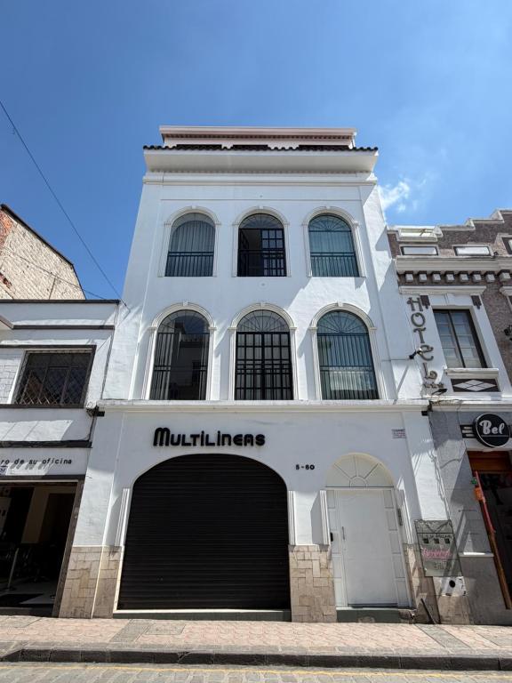 a large white building with a large garage at Suite Vlady in Cuenca