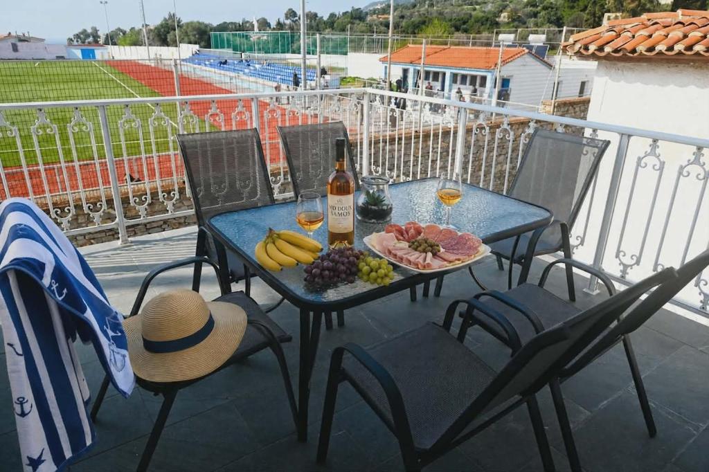 a table with a plate of fruit and a bottle of wine at George's Stonehouse in Samos