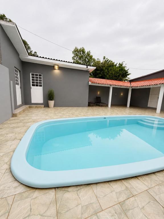 a large blue swimming pool in front of a house at Farol House in Pântano Grande