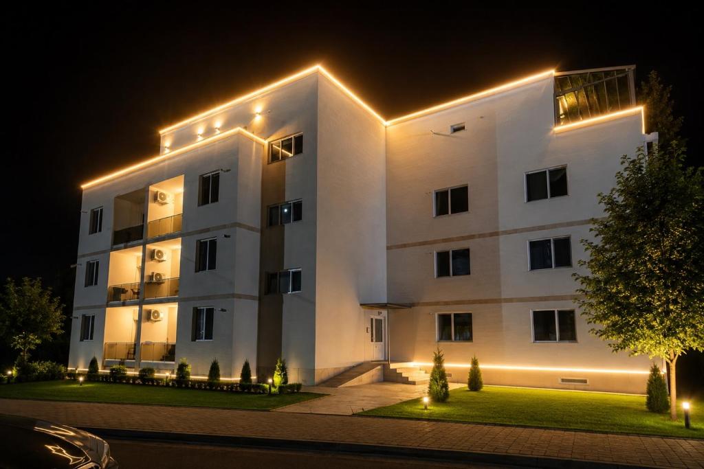 a white building with lights on it at night at Rion Apartments in Saturn