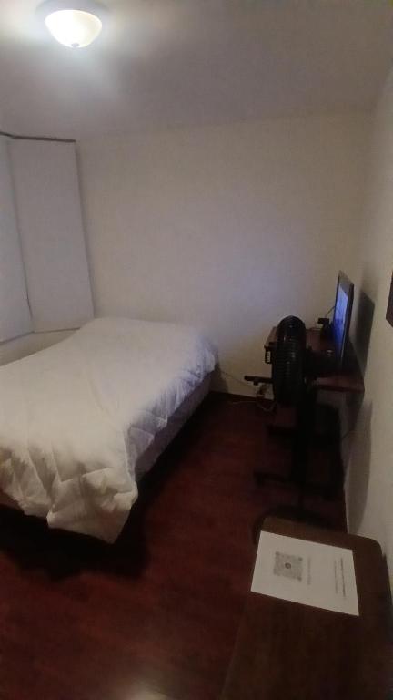 a small bedroom with a bed and a television at Residencia El Navegante 1 in Mexico City