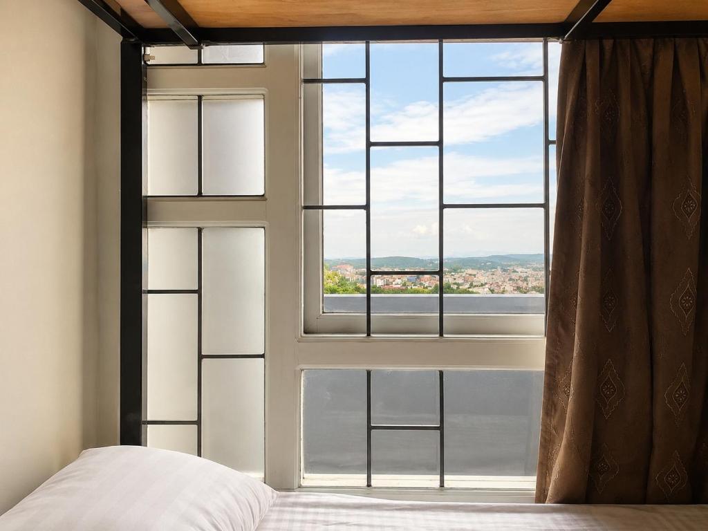 a bedroom with a large window with a bed in front at Hi Hostels Shillong in Shillong