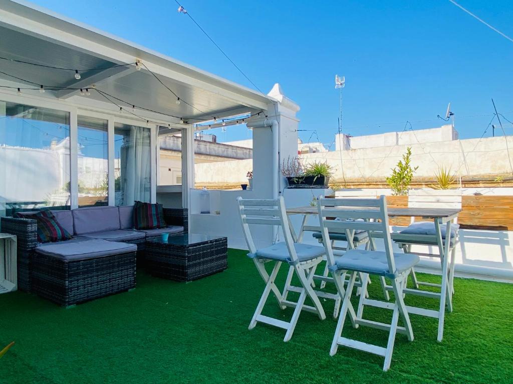 a patio with a table and chairs under a canopy at Ático Cádiz Suite in Cádiz