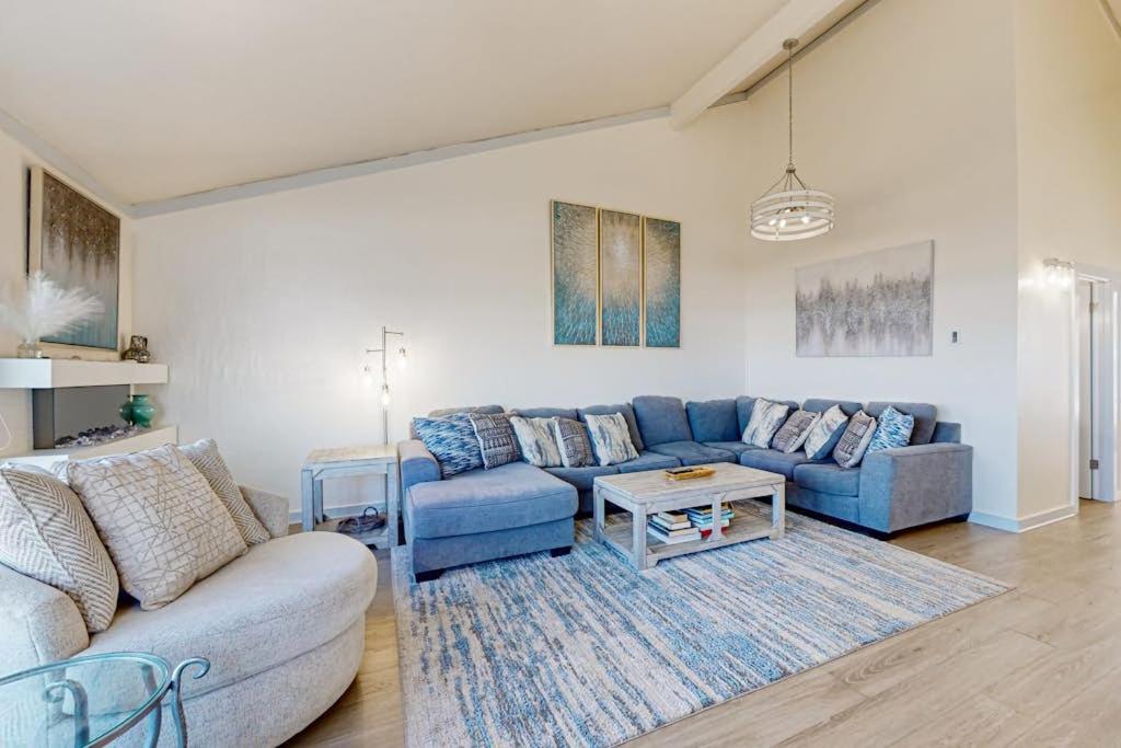 a living room with a blue couch and a table at Monterey Dune Dream in Moss Landing