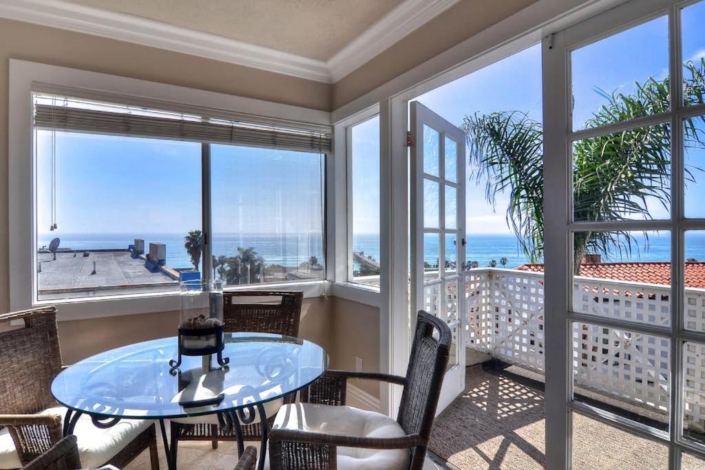 a balcony with a glass table and chairs and the ocean at San Clemente - Monterey Fourplex in San Clemente