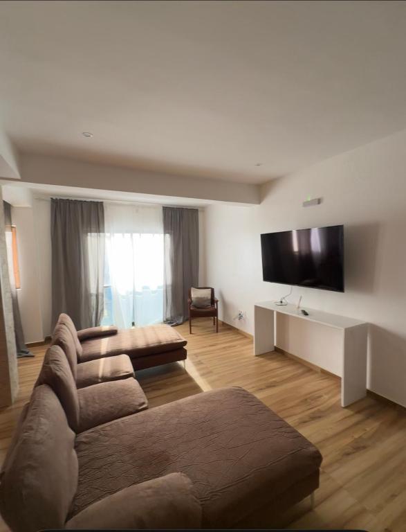 a living room with a couch and a flat screen tv at Casa da Tá in Espargos