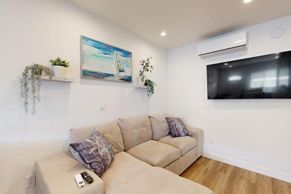 a living room with a couch and a flat screen tv at Fair Weather in Newport Beach