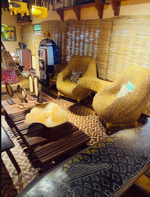 a living room with wicker chairs and a table at Casa Quietude - Manaus - Manacapuru in Manacapuru