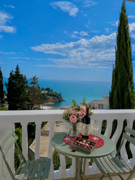 a table with wine bottles and flowers on a balcony at Apartments Buena Vista in Ulcinj