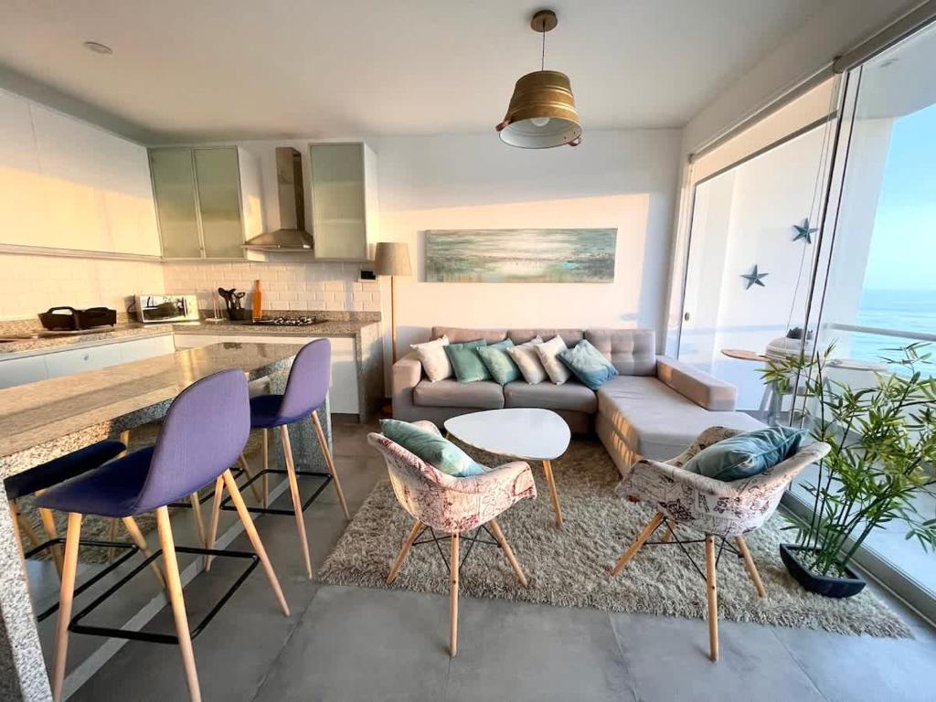 a living room with a couch and a table and chairs at Beach view apartment Punta Hermosa 4BR in Punta Hermosa