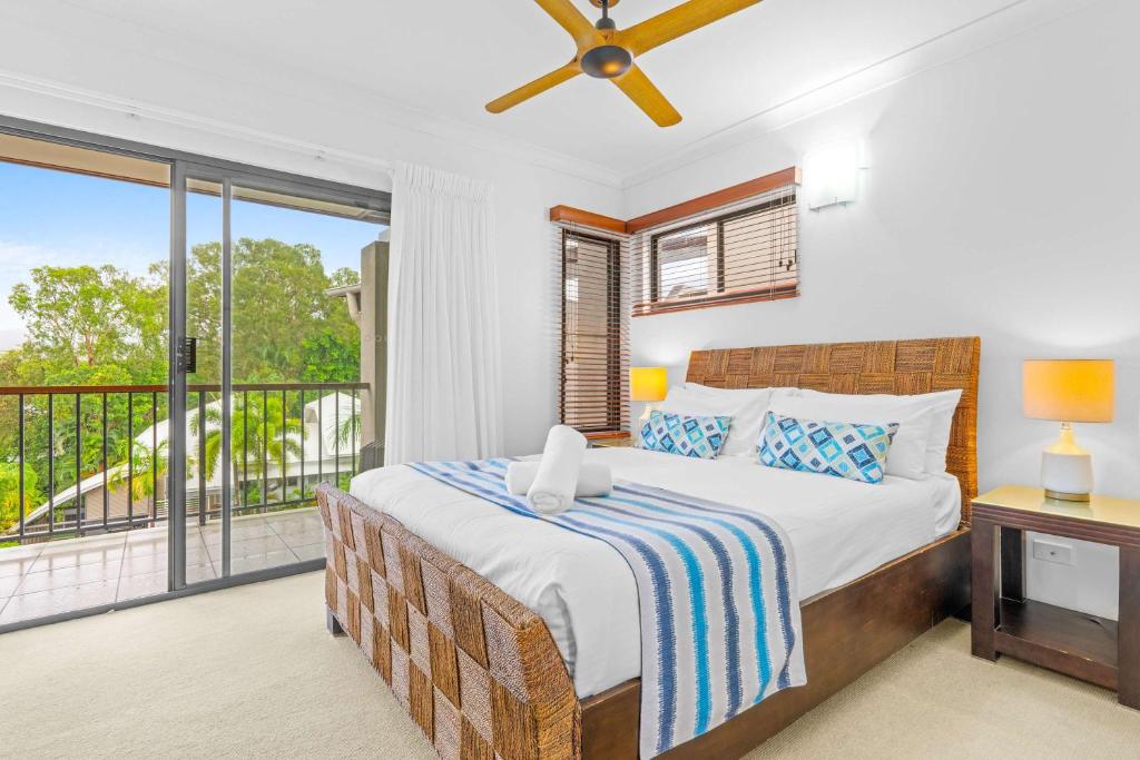 a bedroom with a bed and a balcony at Bluewater Haven - Sweeping Lagoon Views with Pool in Trinity Beach