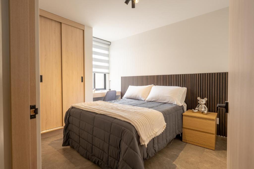 a bedroom with a bed and a teddy bear on a night stand at Un escape moderno dentro de Zibatá in San Vicente Ferrer