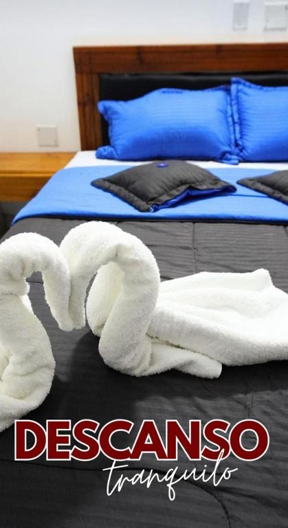 a towel animal is laying on a bed at Hotel Plazas Millas Merida in Mérida