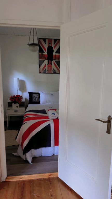 a bedroom with a bed with a red white and black blanket at BAPA STAYs in Kristianstad
