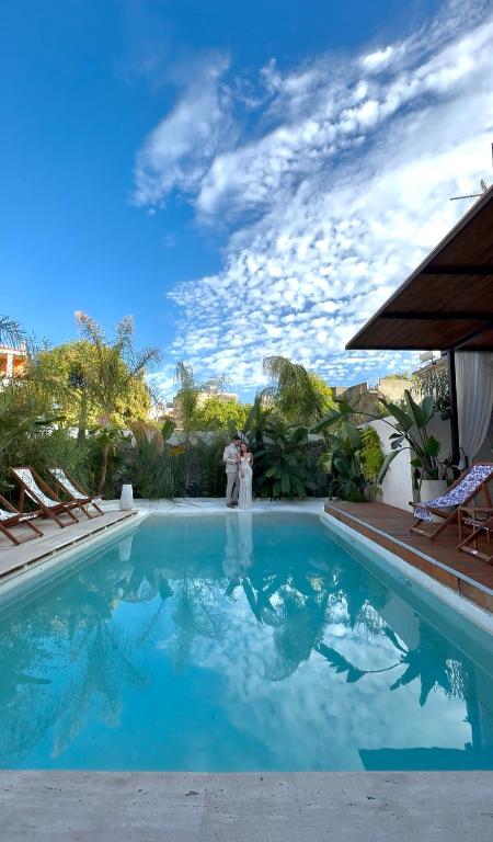 a bride and groom standing next to a swimming pool at Casa Palma Suites in Vlorë