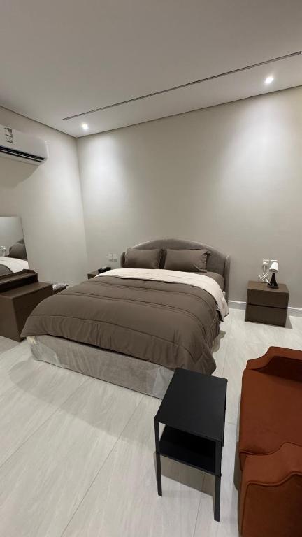 a bedroom with a large bed and a couch at سويت بغرفة نوم شوحط in Abha
