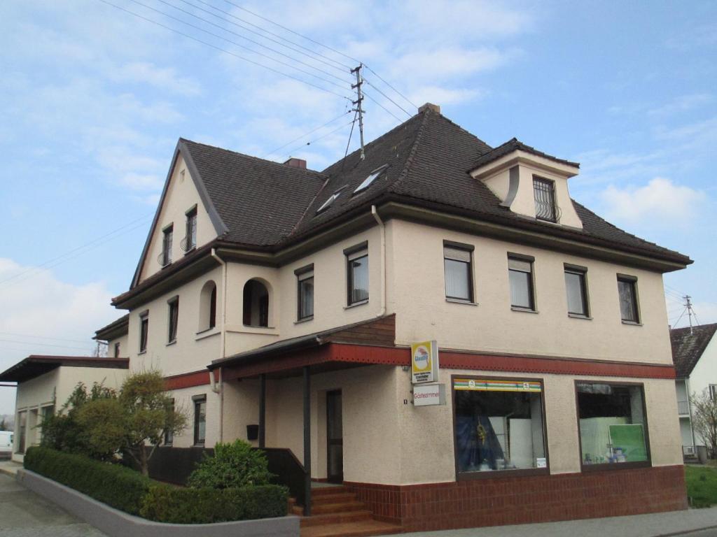 ein großes weißes Haus mit schwarzem Dach in der Unterkunft Gästehaus Kranzfelder in Zusmarshausen