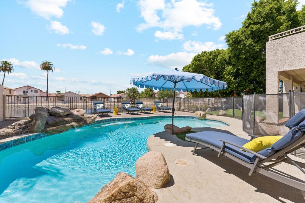 a swimming pool with an umbrella and a reclining chair at Resort-Style 5BR Heated Pool Putting Green in Glendale
