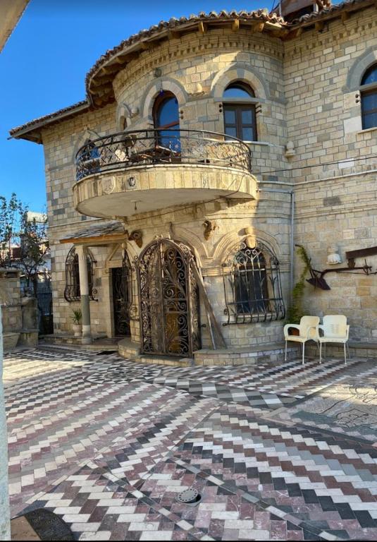 a large stone building with a balcony on top of it at Stone House in Vlorë