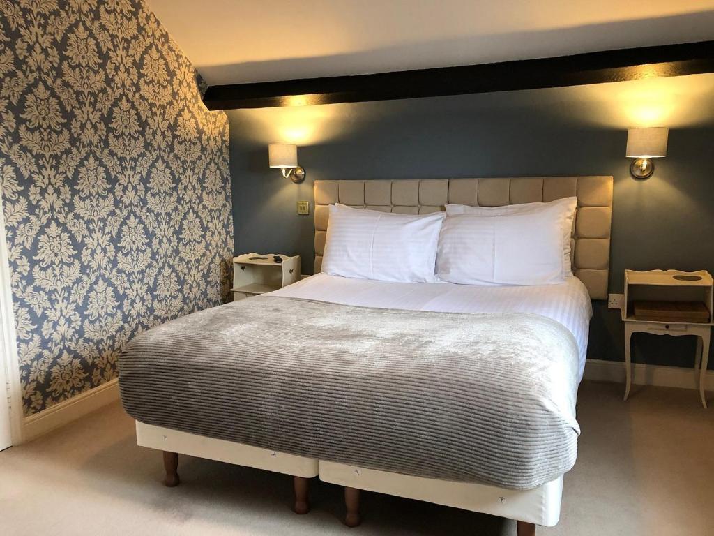 a bedroom with a large bed with white pillows at The Coachmakers Arms in Wallingford