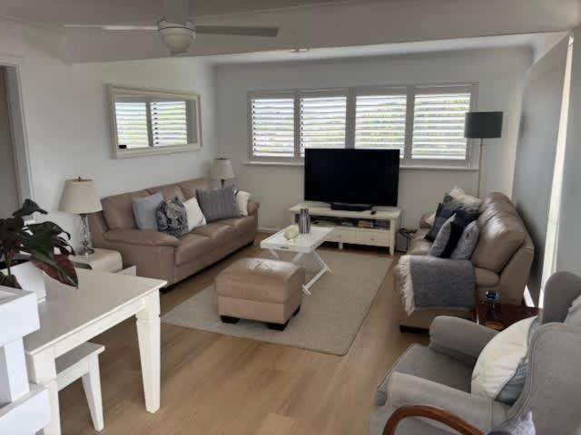 a living room with couches and a flat screen tv at 2 Shore Ct - Shore Thing in Goolwa South